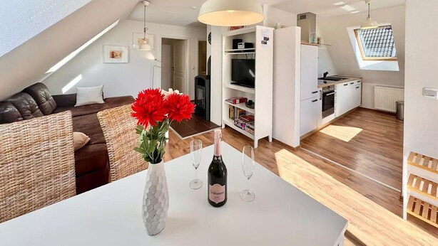 Un apartamento moderno con zona de estar tipo loft, cocina y comedor.