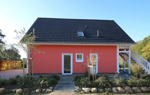 A red building with a tiled roof, a small window, and a door. There is a wooden staircase leading up to a porch. - Beautiful apartment in Röbel with sauna (Röbel)