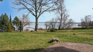 Une zone herbeuse avec un chemin pavé menant à un quai au bord d’un lac.