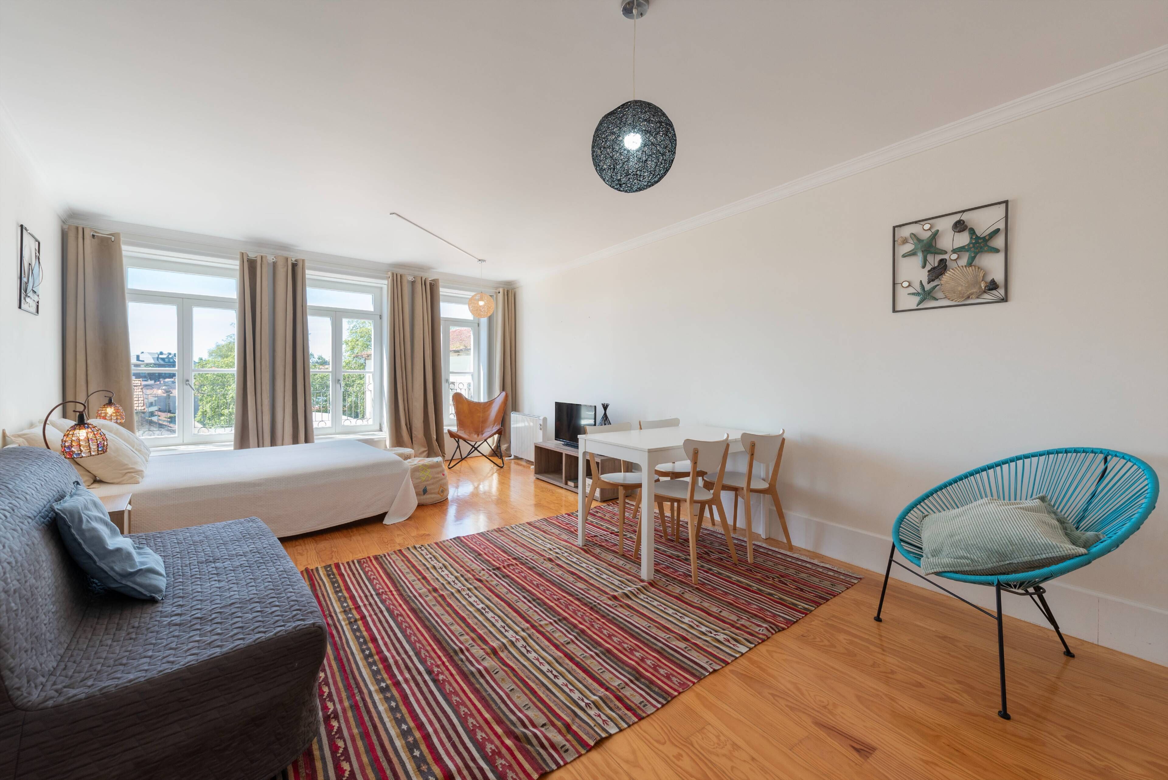 Une chambre moderne et bien éclairée, équipée d’un lit, d’un bureau et d’une chaise.