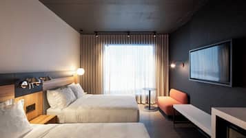 Une chambre d’hôtel avec deux lits, une télévision, un bureau et une chaise.
