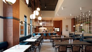 Un restaurante con cabinas, mesas, luces colgantes, una zona de cocina y una barra.