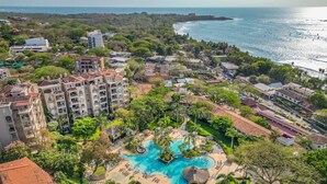 A resort with multiple swimming pools, lush greenery, and beachfront views. - Tamarindo Diria 403 Luxury Ocean View Condo (Tamarindo)