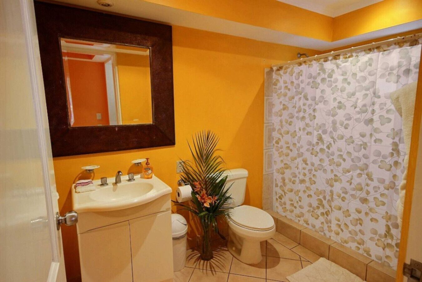 A bathroom with a sink, toilet, and shower curtain.