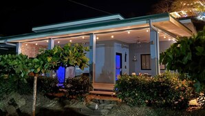A modern house with a covered porch, a visible door, and a small outdoor seating area. - Villa Sol y Mar Shared Pool 2 miles to Beach (Potrero)