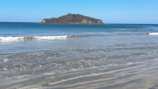 A beach with a sandy shore and a small rocky island in the distance. - Villa Sol y Mar Shared Pool 2 miles to Beach (Potrero)