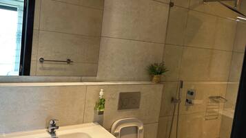 Un baño moderno con un lavamanos grande y blanco, un bidé y una cabina de ducha.