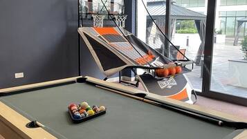 Una mesa de billar con aro de baloncesto y un atril para bolas de billar.