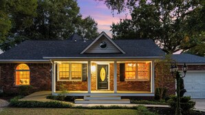 A two-story house with a front porch, a garage, and a well-maintained lawn. - Rooster Row Cottage w/ Pool, Jacuzzi, Fire Pit + Poker Room. Sleeps 12! (West Columbia)