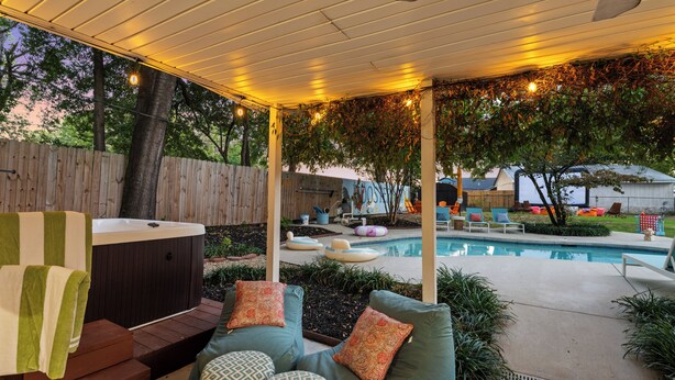 A covered outdoor area with a hot tub, seating, and a pool. - Rooster Row Cottage w/ Pool, Jacuzzi, Fire Pit + Poker Room. Sleeps 12! (West Columbia)