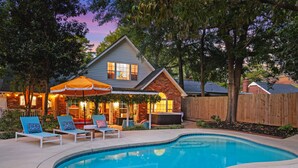 A backyard with a swimming pool, lounge chairs, and a patio area. - Rooster Row Cottage w/ Pool, Jacuzzi, Fire Pit + Poker Room. Sleeps 12! (West Columbia)