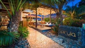 A well-lit outdoor area with a stone pathway, seating arrangements, and a sign that reads "spirula". - Ocean View w Pool Roble Sabana in Reserva Conchal (Reserva Conchal)