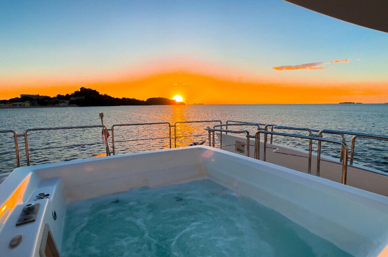 A boat with a hot tub and a sunset view.