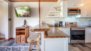 A modern kitchen with wooden cabinetry, a built-in oven, a microwave, and a coffee maker. - Cultural Charm and Ocean Views in Playa Flamingo (Playa Flamingo)