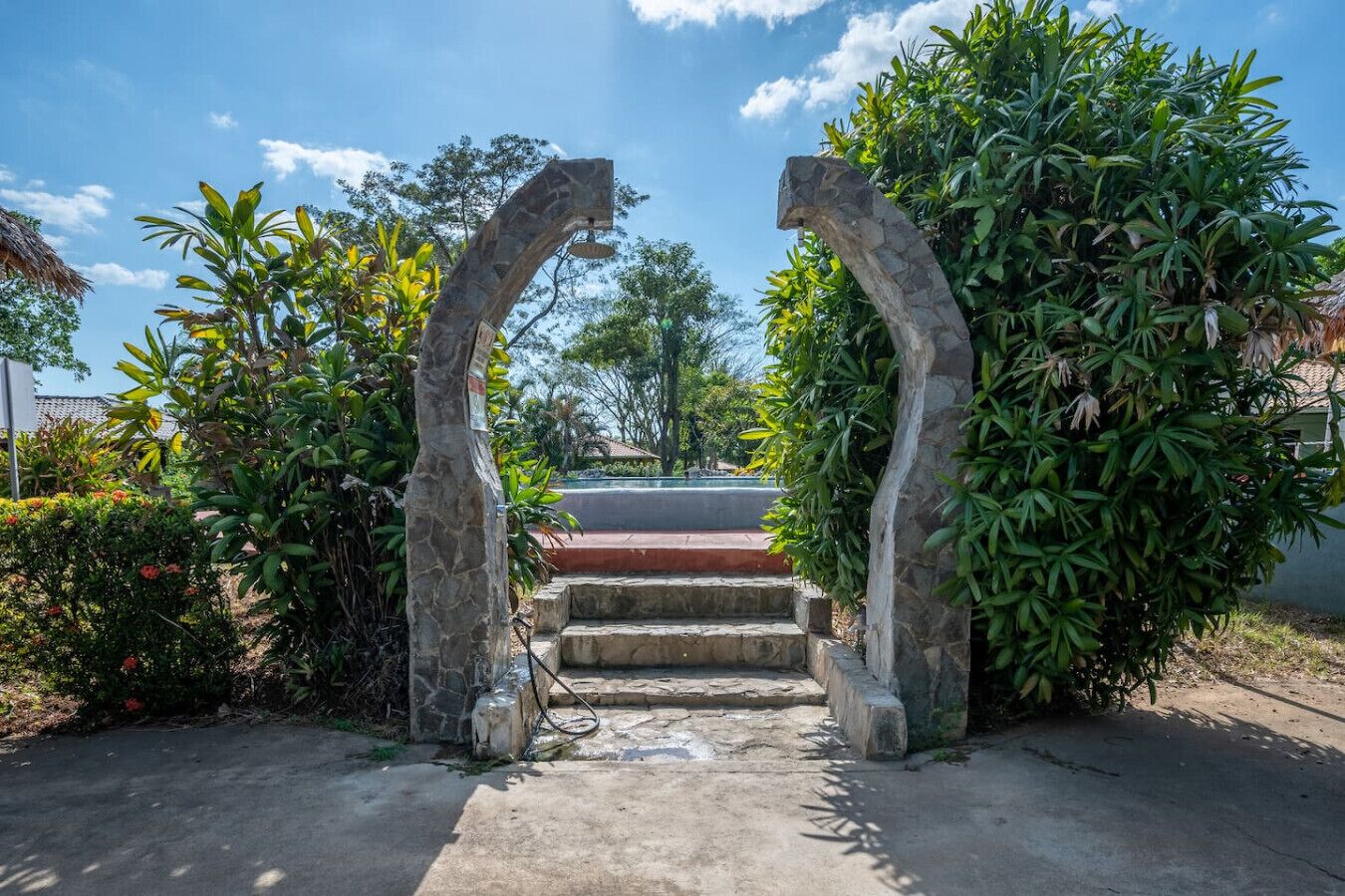 Un chemin menant à l’entrée d’un bâtiment, avec des arches et des marches en pierre.
