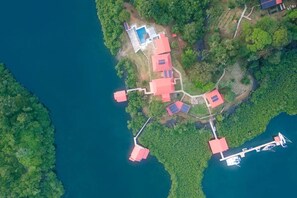 A coastal property with multiple buildings, a swimming pool, and solar panels.
