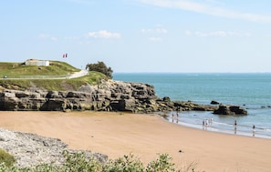 A coastal landscape with a sandy beach, rocky cliffs, and a flag on a hill. - 2 bedroom lovely home in Chenac-Saint-Seurin-d' (Chenac-Saint-Seurin-d')