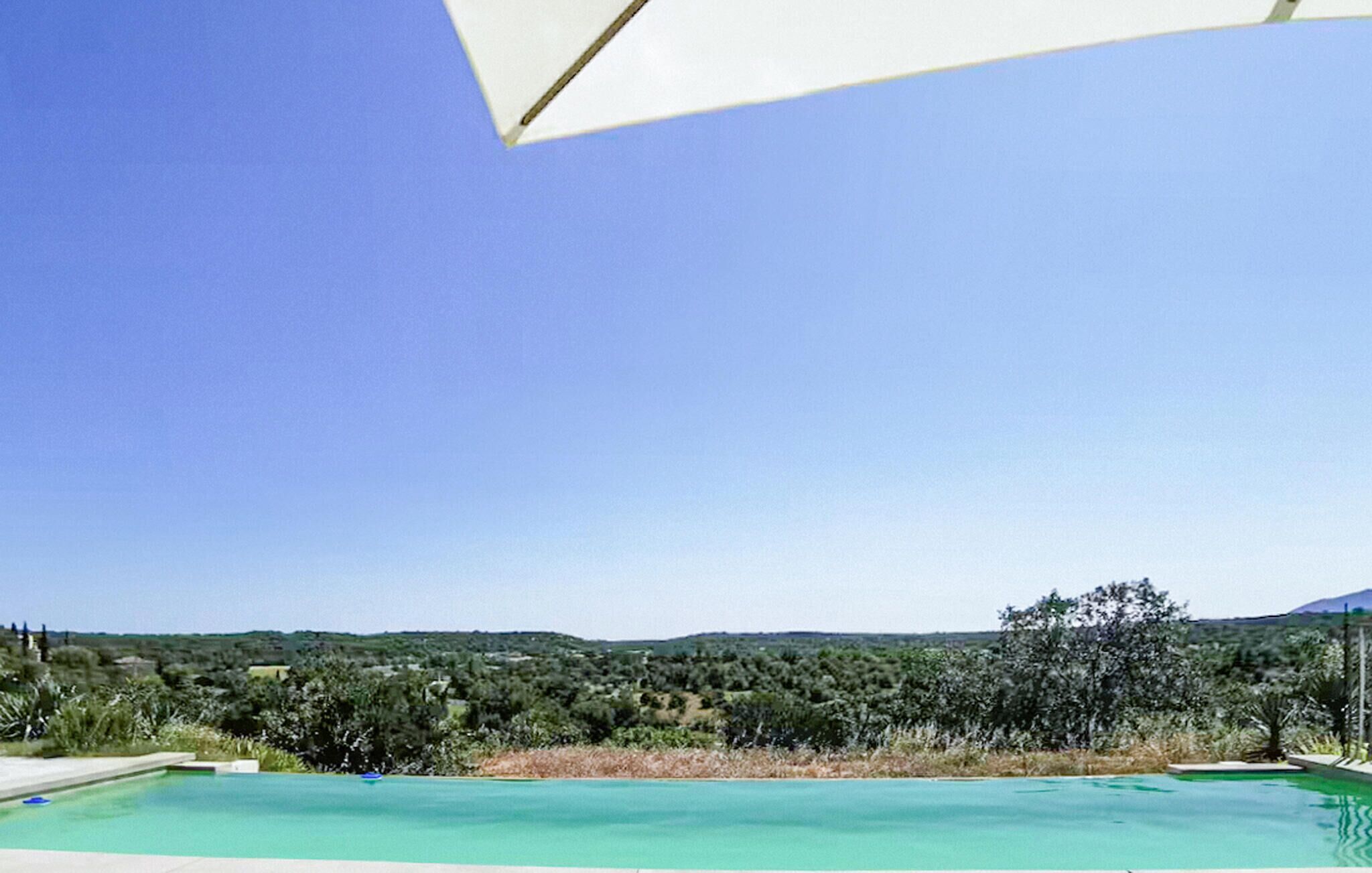 Una piscina con vista despejada del paisaje circundante y colinas lejanas.