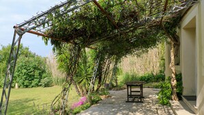 A garden pathway leading to a wooden bench under a pergola covered with climbing plants. - Amazing home in Lussan (Lussan)