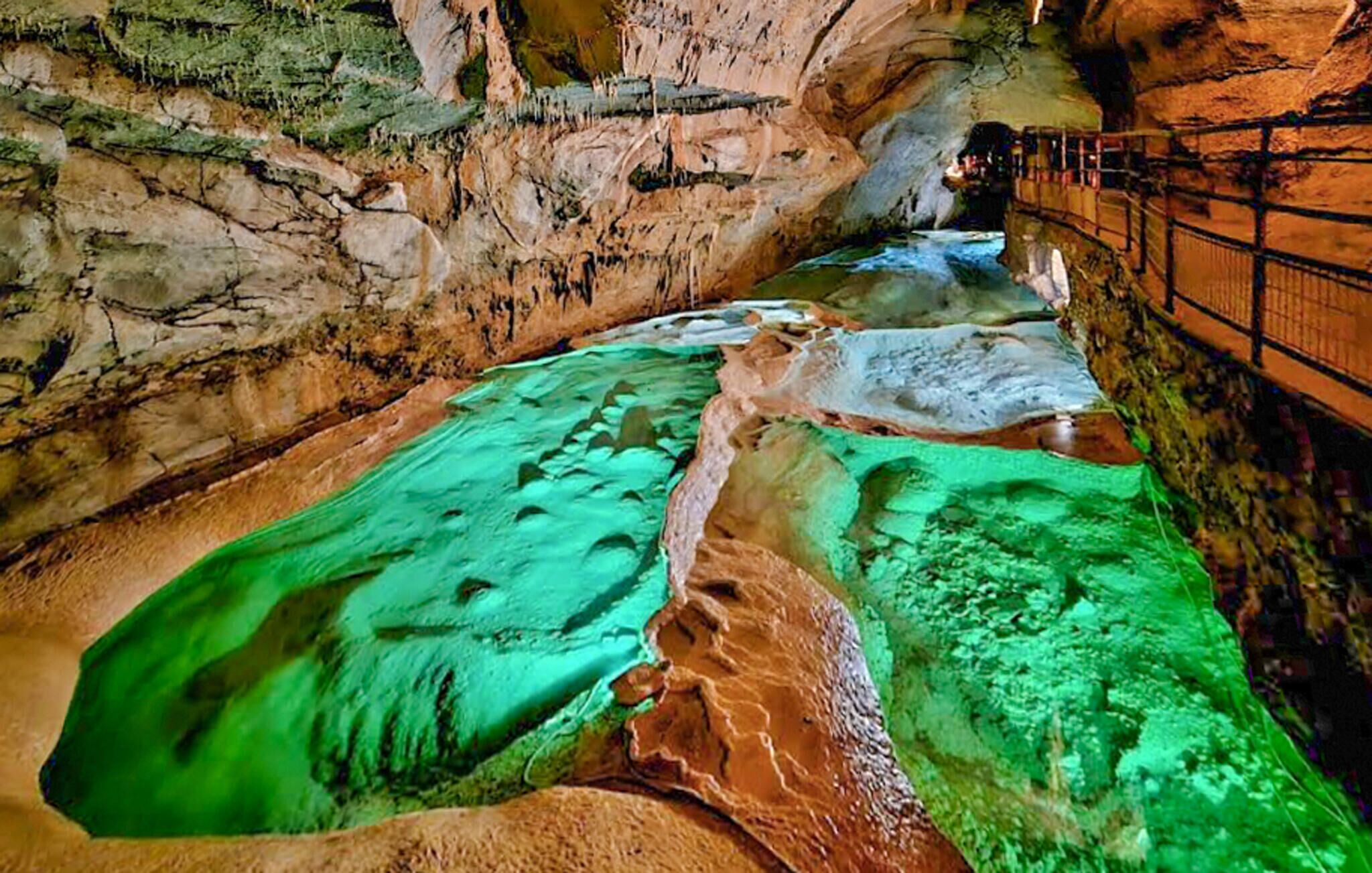 A cave with a river flowing through it, surrounded by rocky walls.