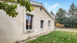 A single-story building with a concrete exterior and three windows. - Amazing home in Lussan (Lussan)