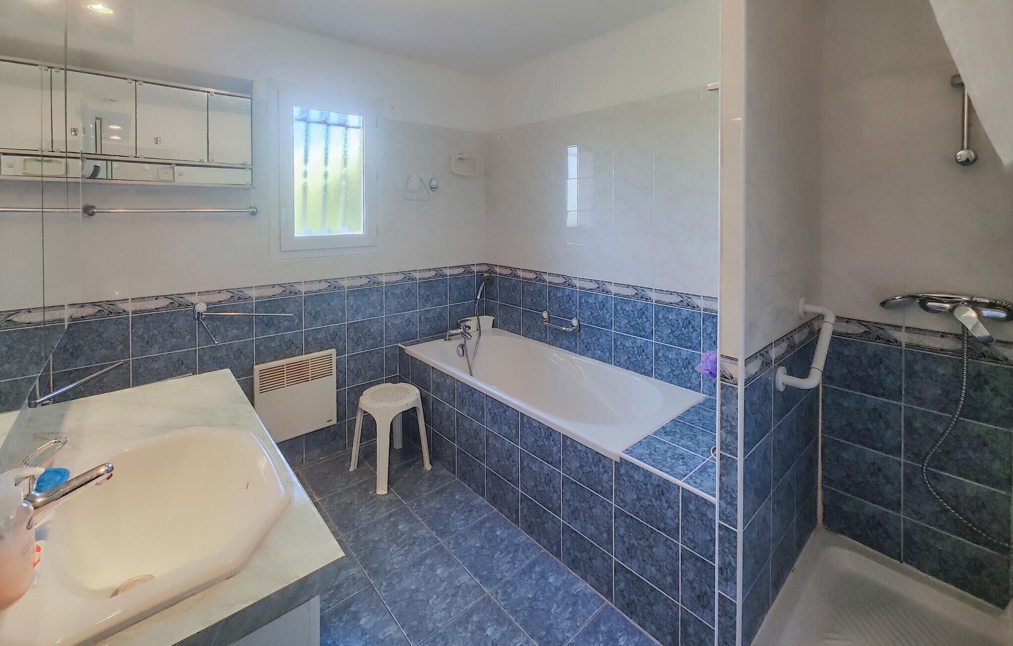 Un baño con bañera, lavamanos y ducha.