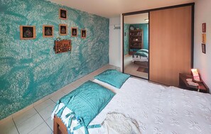 A bedroom with two beds, teal patterned walls, and a large mirror. - 2 bedroom pet friendly apartment in Sète (Sète)