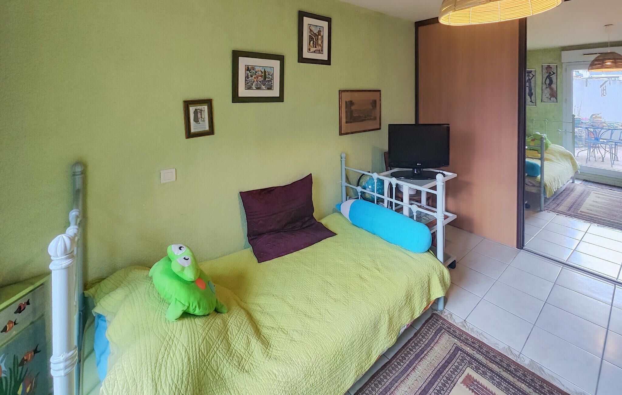 A bedroom with a bed, a television, and a window.