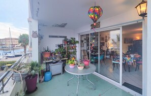 A balcony with potted plants, a table, and a hot air balloon decoration. - 2 bedroom pet friendly apartment in Sète (Sète)