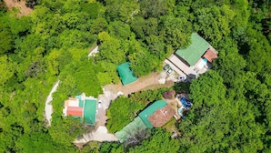 An aerial view of a property with multiple buildings, surrounded by dense greenery. - Serene Mar Azul Zen Villa w/ Pool & Yoga Platform (Huacas)