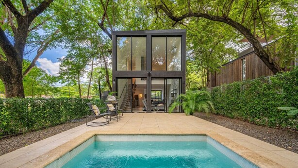 A modern house with a swimming pool, surrounded by lush greenery and trees. - Casa Teca in Surfside w/ Pool near Beach (Potrero)