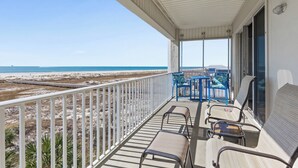A covered balcony with a view of the beach, featuring a table and chairs. - The View ~ Top Floor ~ Amazing Views (Dauphin Island)
