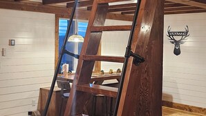 Eine Holztreppe mit Metallgeländer, die zu einer zweiten Etage führt.
