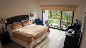 A hotel room with a large bed, a balcony with a view, a desk, and a chair. - Campestre La Fuente  (Monterrey)