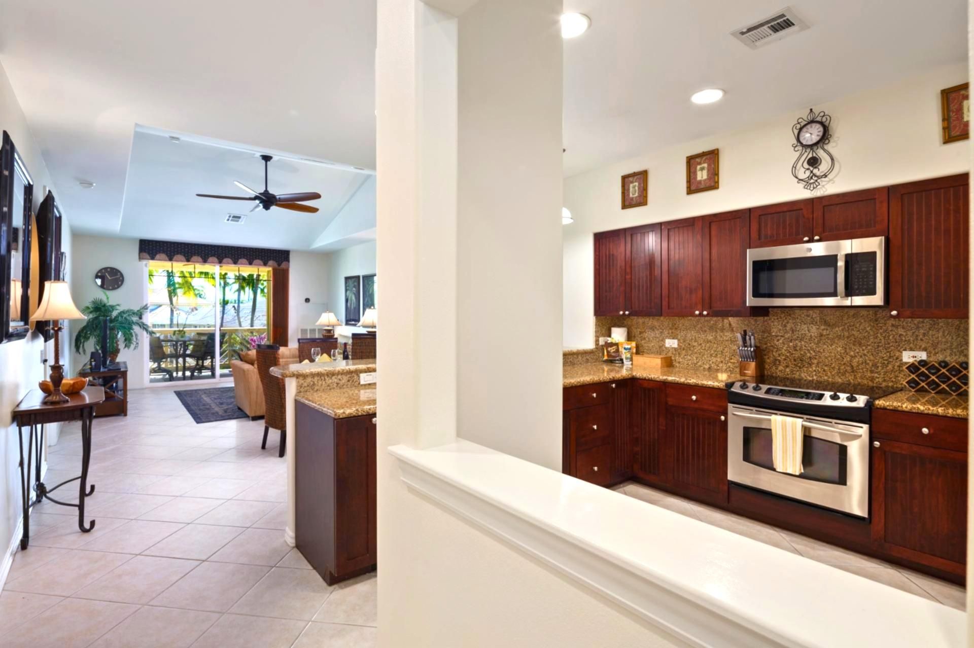 A modern kitchen with dark wood cabinets, stainless steel appliances, and a granite countertop.