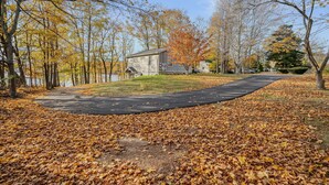 A pathway leading to a house with a pond in the background. - Lake House—Unit B (East Lyme)