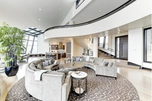 A spacious living area with a curved sofa set, a coffee table, and a large potted plant. - The Colony | Walk To Slopes, Hot Tub, Parking | KBM Resorts | Walk to Slopes, Hot Tub, Parking | 2 homes, 9 Bedrooms |  ML-2510 (Park City)