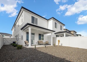 A two-story house with a covered patio area, a white exterior, and a gravel driveway. - The Roost, Luxe Star Idaho Stay w/ 65" TV & Zippy Wi-Fi, Sleeps 8 (Star)