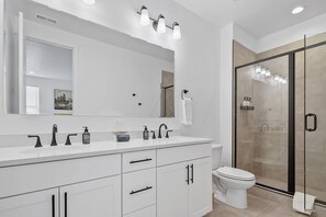 A modern bathroom with a white vanity, a large mirror, a glass shower enclosure, and a toilet. - The Roost, Luxe Star Idaho Stay w/ 65" TV & Zippy Wi-Fi, Sleeps 8 (Star)