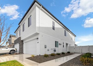 A modern two-story house with a garage, a driveway, and a well-maintained lawn.