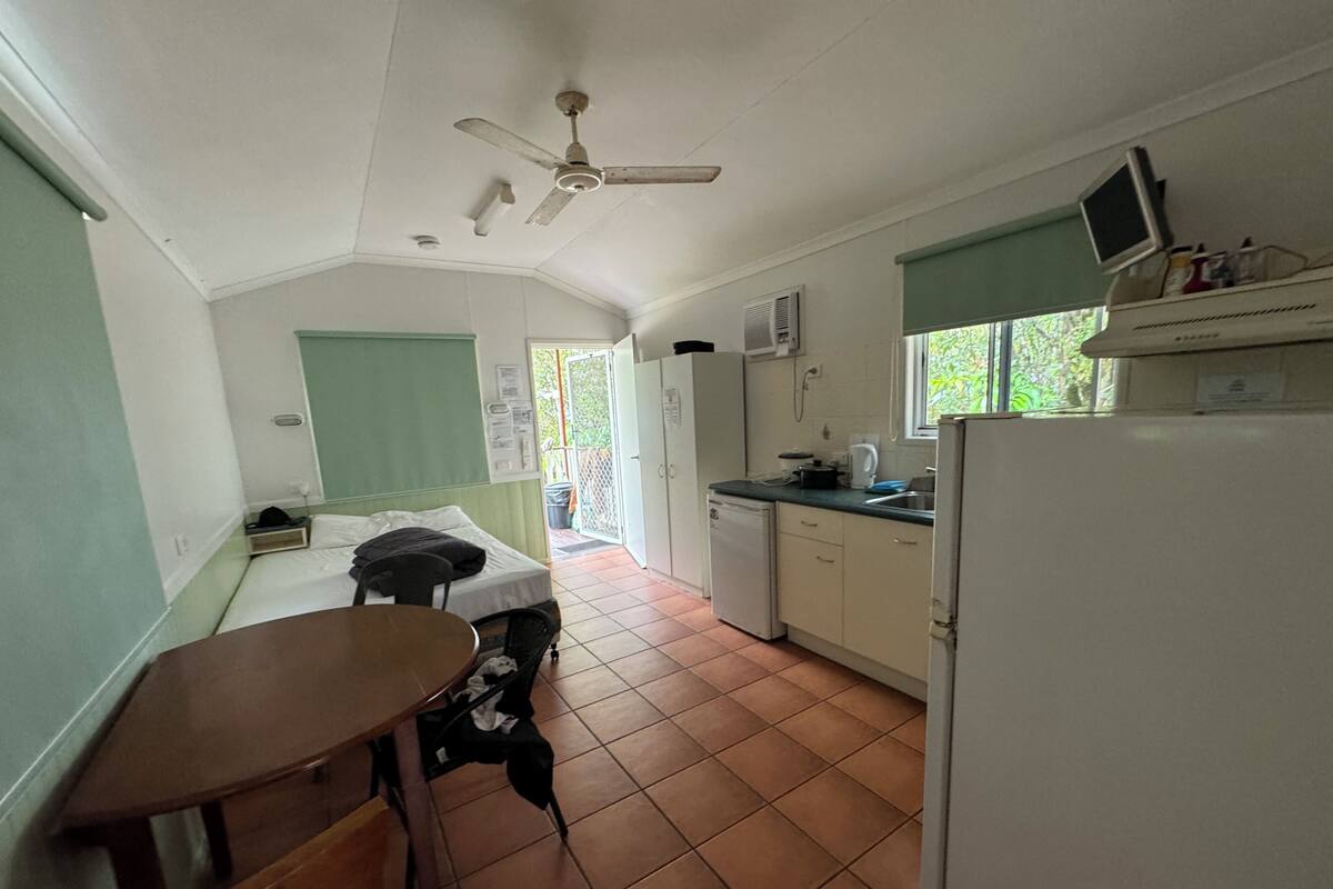 Una cocina compacta con comedor, ventilador de techo y un refrigerador pequeño.