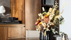 A modern kitchen with wooden cabinets, a microwave, and a vase of flowers on the counter. - Upscale 2BR/2BA Apartment with Incredible Mountain Views (Oaxaca de Juárez)