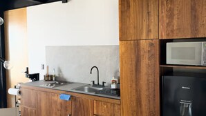 A modern kitchen with wooden cabinets, a stainless steel sink, and a black refrigerator. - Upscale 2BR/2BA Apartment with Incredible Mountain Views (Oaxaca de Juárez)