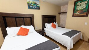 Two single beds with wooden headboards, white bedding, and orange pillows. - Hotel Maria Bonita (Tequila)