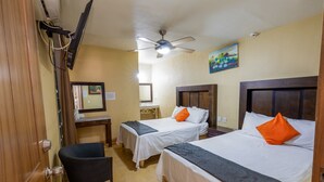 A hotel room with two beds, a desk, a chair, a ceiling fan, and a painting on the wall. - Hotel Maria Bonita (Tequila)