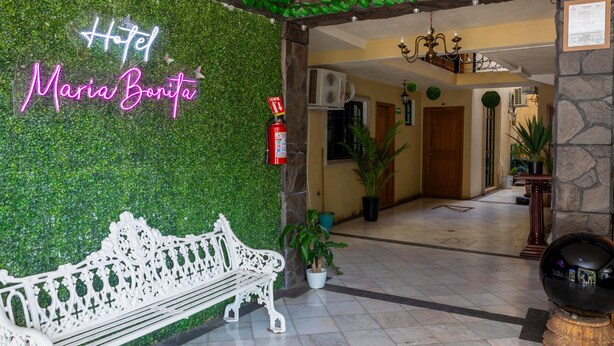 A hotel lobby with a green wall, a white bench, and a sign that reads "Hotel Maria Bonita." - Hotel Maria Bonita (Tequila)