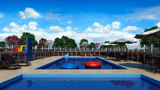 Piscina con sillas de descanso y sombrillas, rodeada por una valla y árboles.