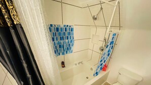 Un baño con bañera, ducha e inodoro.