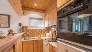 Een keuken met houten kastjes, een Bosch oven en een vaatwasser.