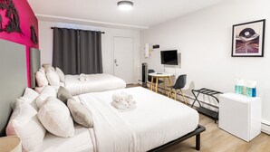 Une chambre d’hôtel avec deux lits, un bureau, une chaise, une télévision et un tableau encadré au mur.